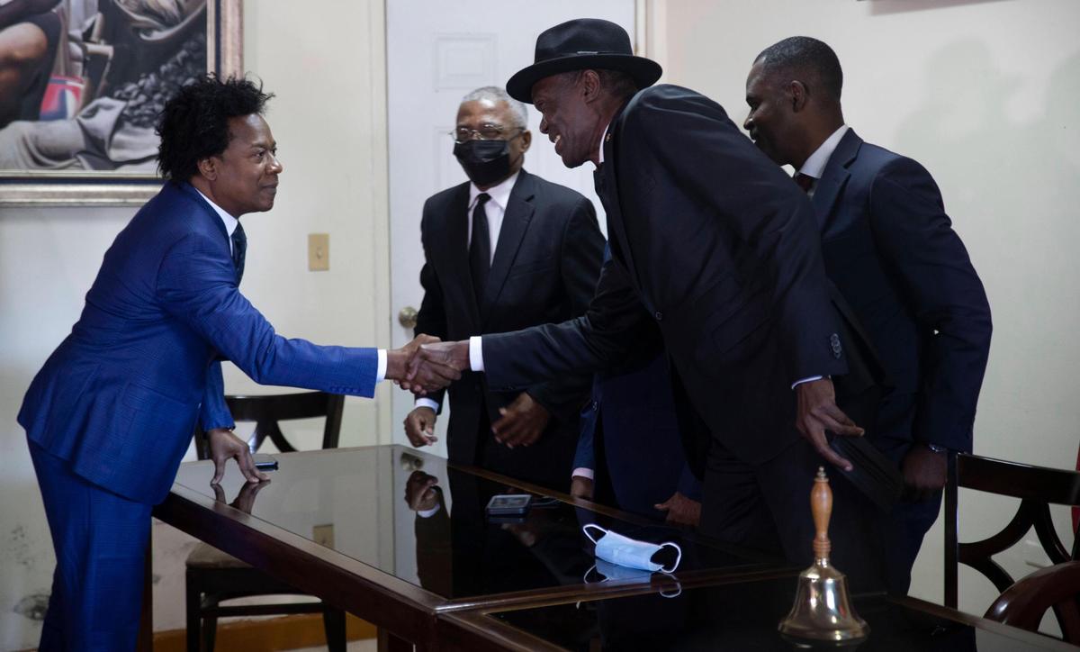 In this file photo, Sen. President Joseph Lambert, center, greets Senator Gracia Delva, left, after a press conference in Port-au-Prince, Haiti, Monday, Jan. 10, 2022. Haiti’s Senate has reconvened for the first time in a year with only a handful of legislators present, a move that highlights the country’s dysfunctional government as it prepares for elections following the assassination of President Jovenel Moïse.