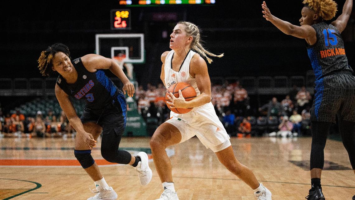 Haley Cavinder (14) drives the ball past Gators KK Deans (3) during the third quarter of an NCAA game between the Miami Hurricanes and the University of Florida on Monday, April 25, 2022, at then Watsco Center.
