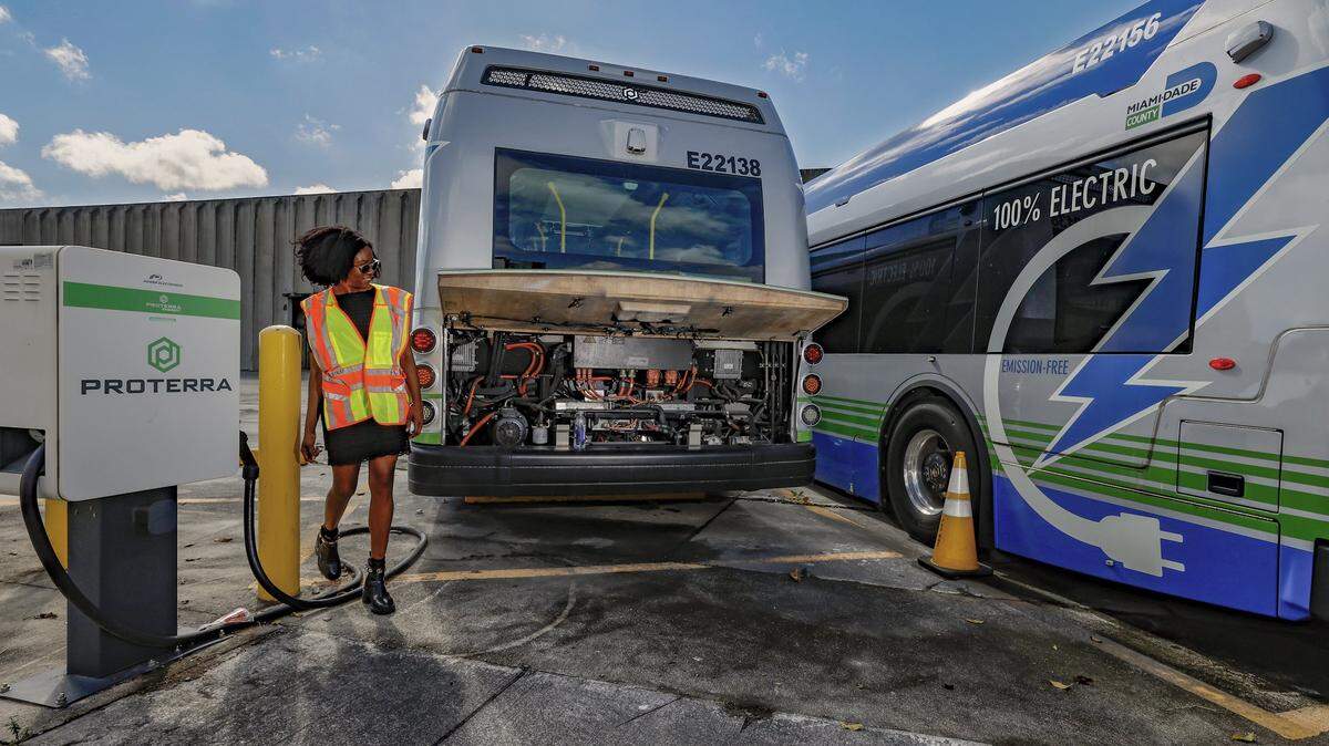 Deborah Souverain, Media and Public Relations Officer for Miami-Dade County Department of Public Works, walks past broken electric Proterra buses parked at Miami-Dade County Coral Way Bus Maintenance Facility in Miami on Wednesday, February 19, 2025.