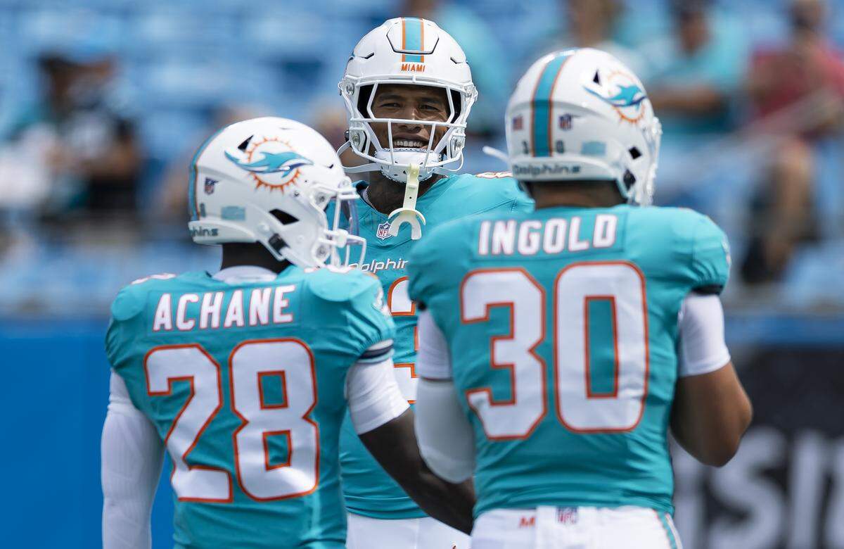 Miami Dolphins running back De'Von Achane (28), tight end Darren Waller (83) and fullback Alec Ingold (30) talk as they prepare to play against the Carolina Panthers in their NFL game at the Bank of America Stadium on Sunday, Oct. 5, 2025, in Charlotte, N.C.