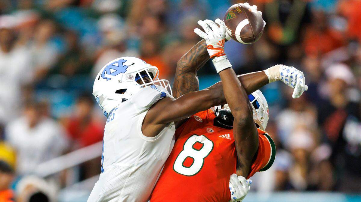 North Carolina Tar Heels defensive back Tony Grimes (1) breaks a pass intended to Miami Hurricanes wide receiver Frank Ladson Jr. (8) during the fourth quarter of an ACC conference football game at Hard Rock Stadium on Saturday, October 8, 2022 in Miami Gardens, Florida..