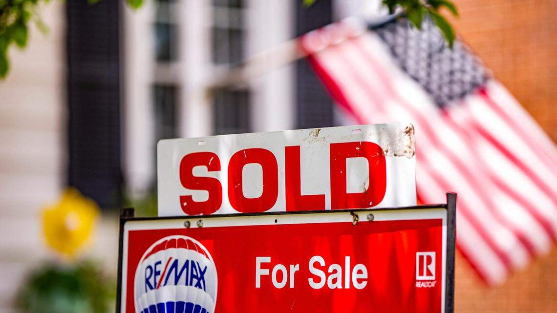 A SOLD sign is attached to a For Sale sign outside a home.