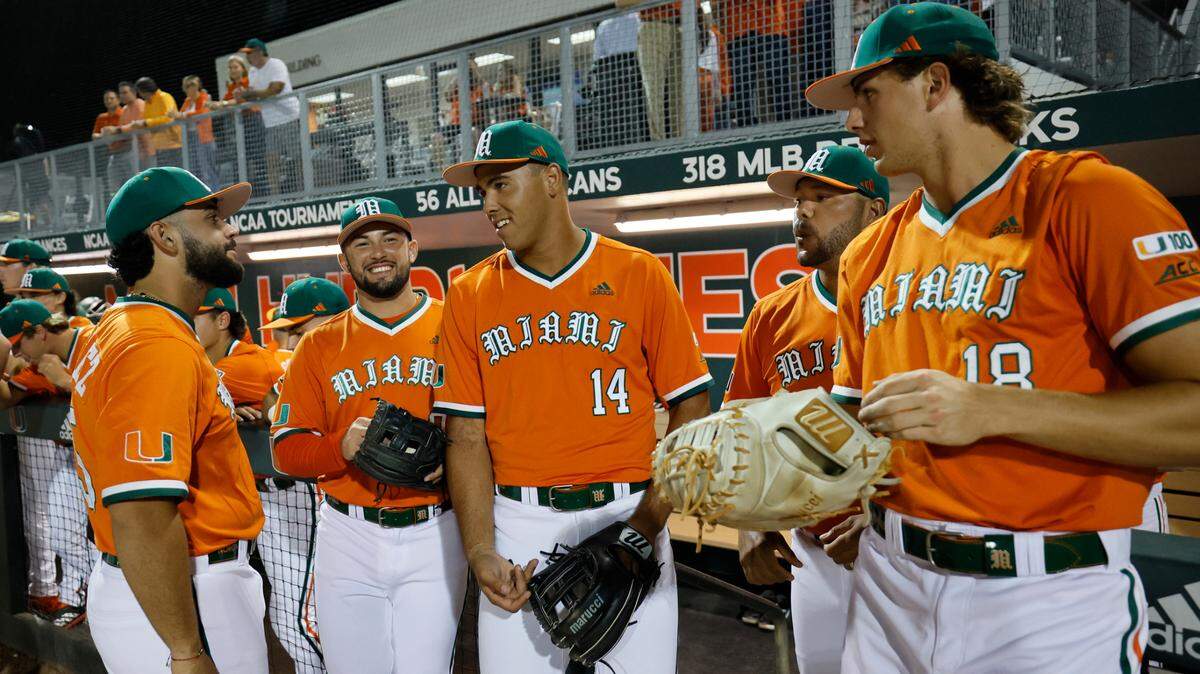 Miami Hurricanes infielder Daniel Cuvet (14) speaks with teammates before the start of the game against Niagara University at Alex Rodriguez Park at Mark Light Field on the University of Miami Campus in Coral Gables, Florida on Friday, February 14, 2025.