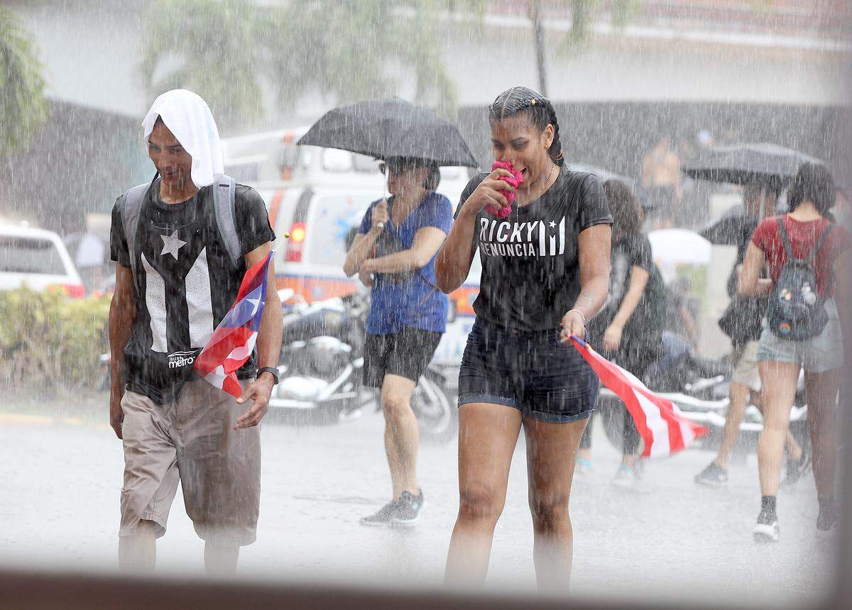 Protesters look for cover from the rain as thousands of Puerto Ricans marched on Las Américas expressway calling for Puerto Rican Gov. Ricardo “Ricky” Rosselló to resign following the leak of private chats. The massive demonstration was Monday, July 22, 2019.