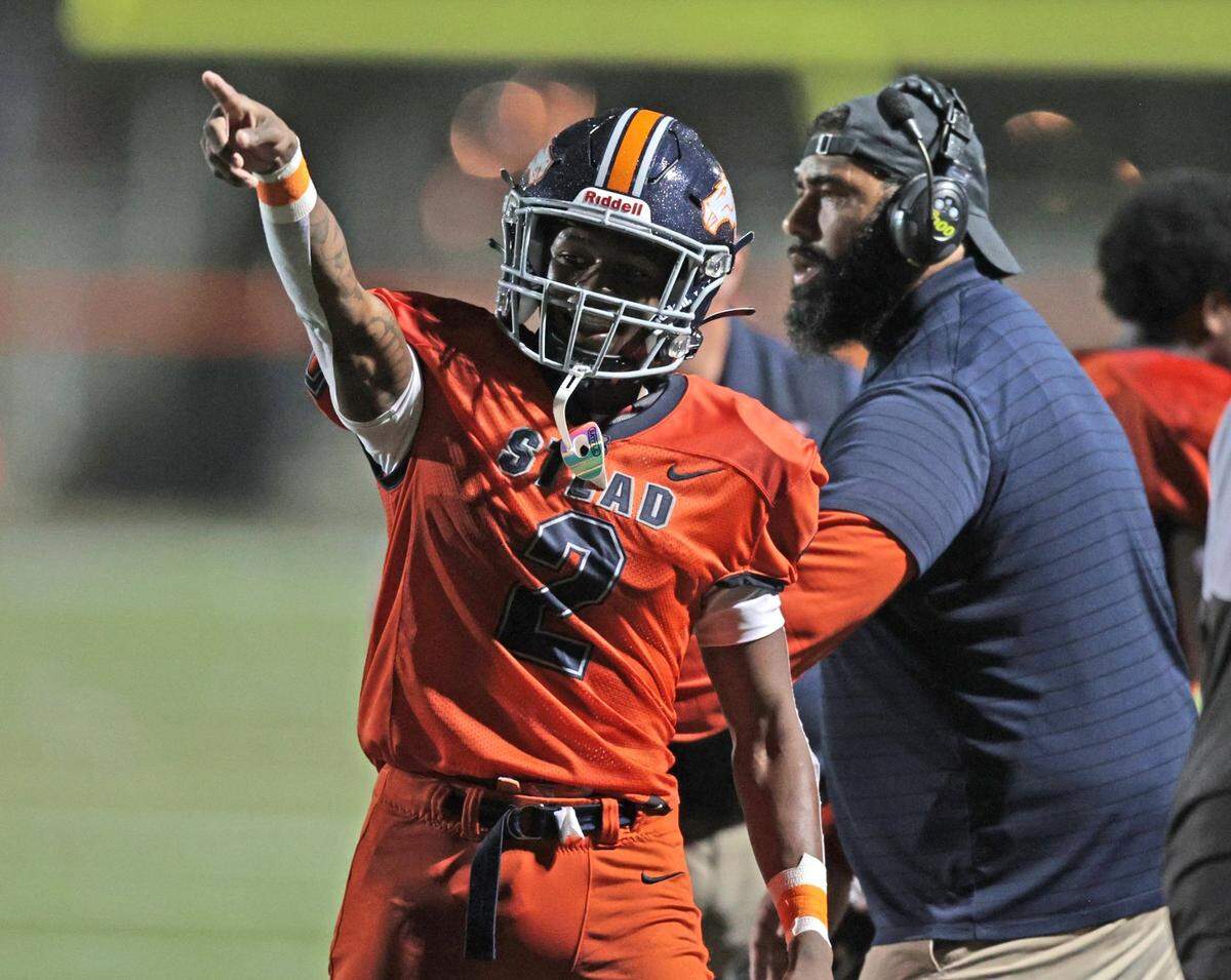 Homestead Broncos wide receiver Richard Dandridge (2) and coach Philip Simpson react after Broncos score against Dillard High at Orange Bowl Field at Harris Field Park in Homestead on Friday, November 19, 2021