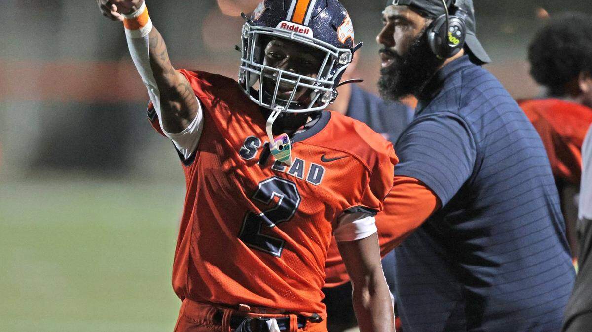 Homestead Broncos wide receiver Richard Dandridge (2) and coach Philip Simpson react after Broncos score against Dillard High at Orange Bowl Field at Harris Field Park in Homestead on Friday, November 19, 2021