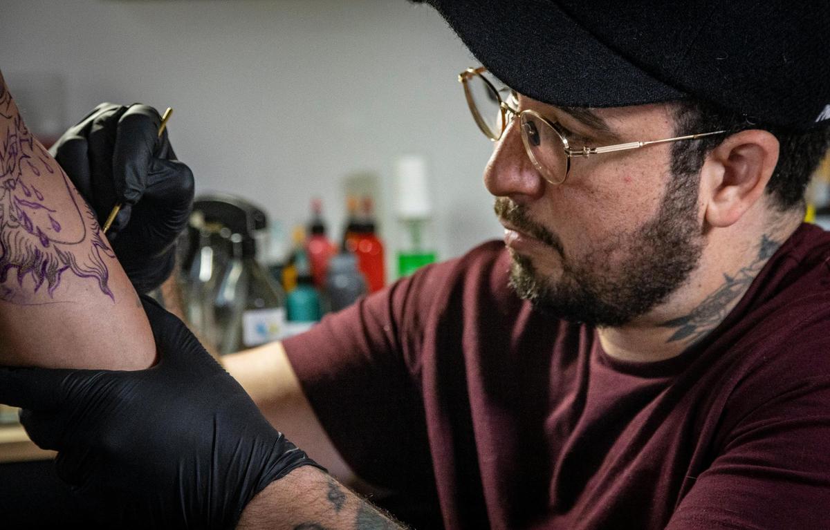 Javier Betancourt works on a piece in his Ocho Placas tattoo shop inside of White Rose Coffee.
