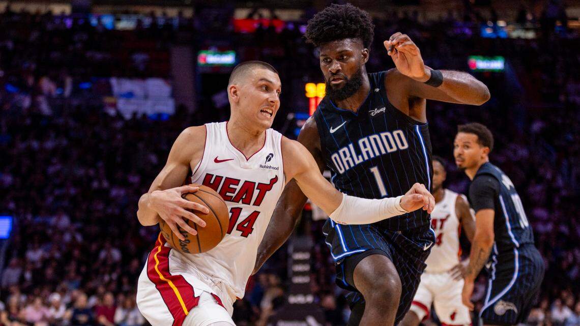 Miami Heat guard Tyler Herro (14) drives on Orlando Magic forward Jonathan Isaacs (1) during the first half of an NBA game on October 23, 2024, in Miami.