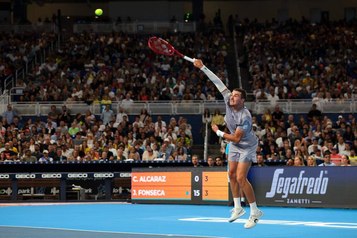 João Fonseca serves to Carlos Alcaraz during their exhibition match at the Miami Tennis Invitational on Monday, Dec. 8, 2025, at loanDepot Park in Miami, Fla.