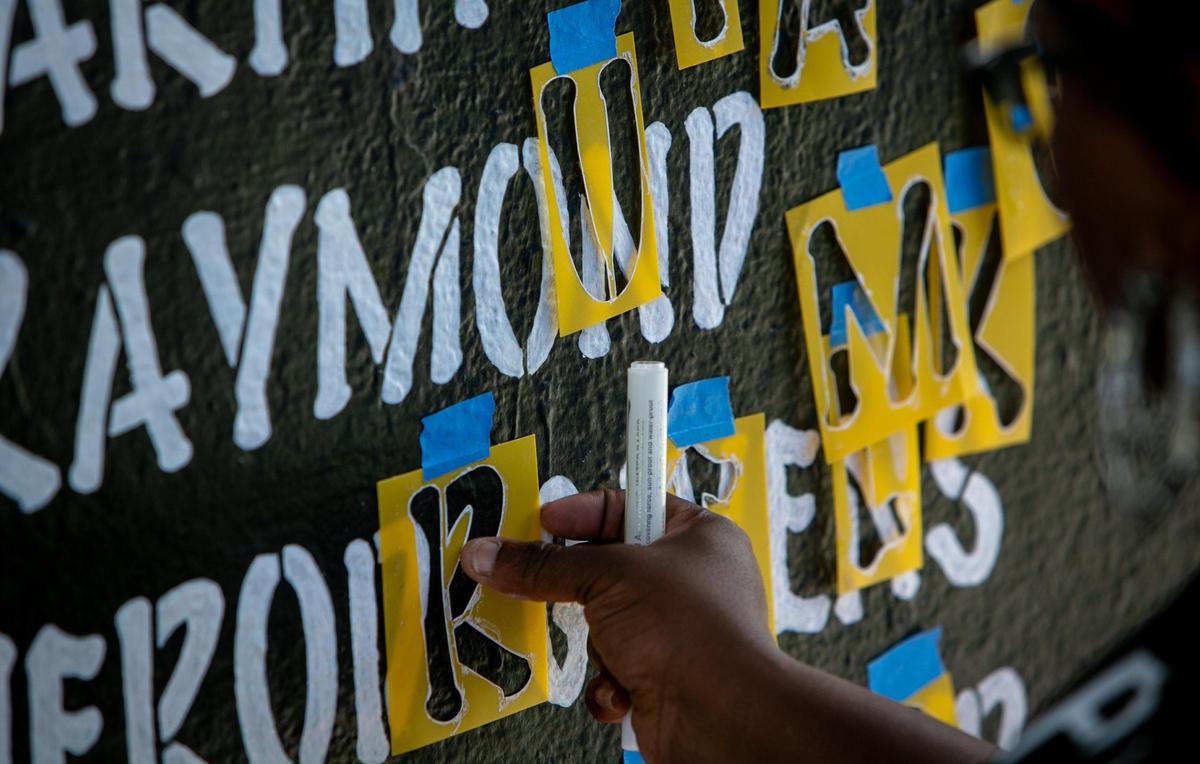 Miami, Florida, December 3, 2020- Artist / Activist Chire Regans works on a mural memorializing victims of gun violence that’s located at the Bakehouse Art Complex, 561 NW 32nd St, Miami, FL 33127