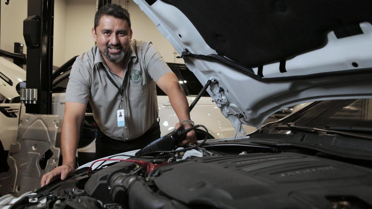 Ronald Miranda poses with a Jaguar engine at the Warren Henry Dealership in North Miami on September 4, 2020.