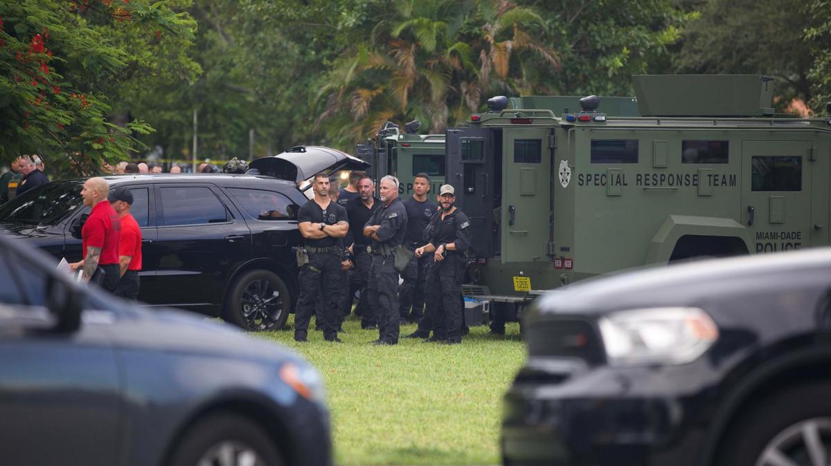 Camiones de respuesta especial de Miami Dade y un agente de policía en la escena en la que un sospechoso fue abatido en la zona del hotel Extended Stay Ameica - Miami Airport en Miami Springs el martes 16 de agosto de 2022.