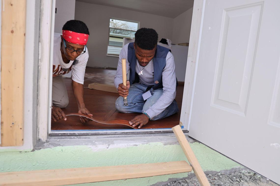 Volunteer Marie Wheeler, 64, left, and Habitat for Humanity of Greater Miami staffer Rickie Wills, 31, right, install flooring on a nearly finished house in the Goulds neighborhood of South Miami-Dade as part of the nonprofit’s annual Blitz Build. The nonprofit recently marked 30 years of operation in Miami.