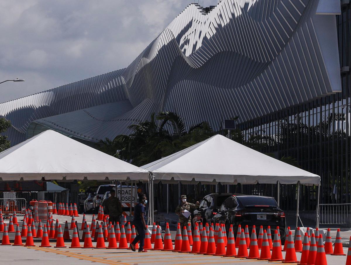Florida National Guard soldiers greet motorists as they enter the Miami Beach Convention Center for COVID-19 testing at the drive-thru mobile testing service entrance on Convention Center Drive. Walk-up testing service was also made available within the municipal parking lot for individuals wishing to be tested on Wednesday, May 20, 2020.