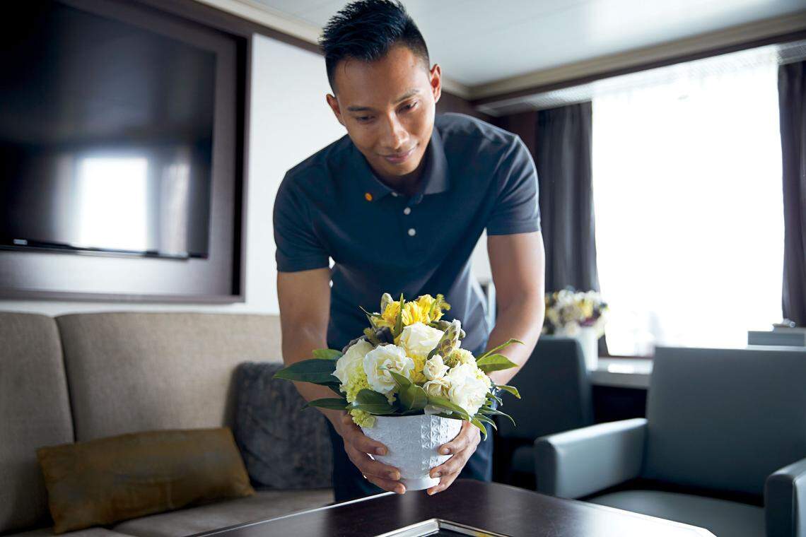 A crew member aboard Holland America’s new ship, Nieuw Statendam, preps flowers in a guest suite.