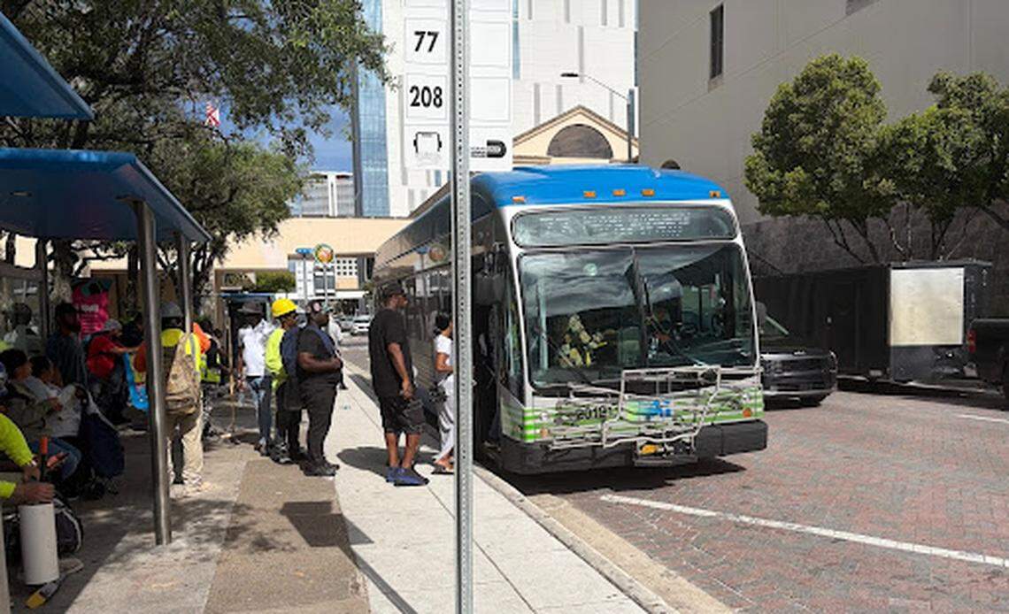 Riders board a Route 77 bus near Government Center in downtown Miami as others wait.