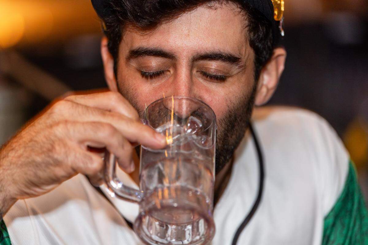 A man drinks water from a mug at Gramps Getaway on Wednesday, September 3, 2025, in Key Biscayne, Fla.