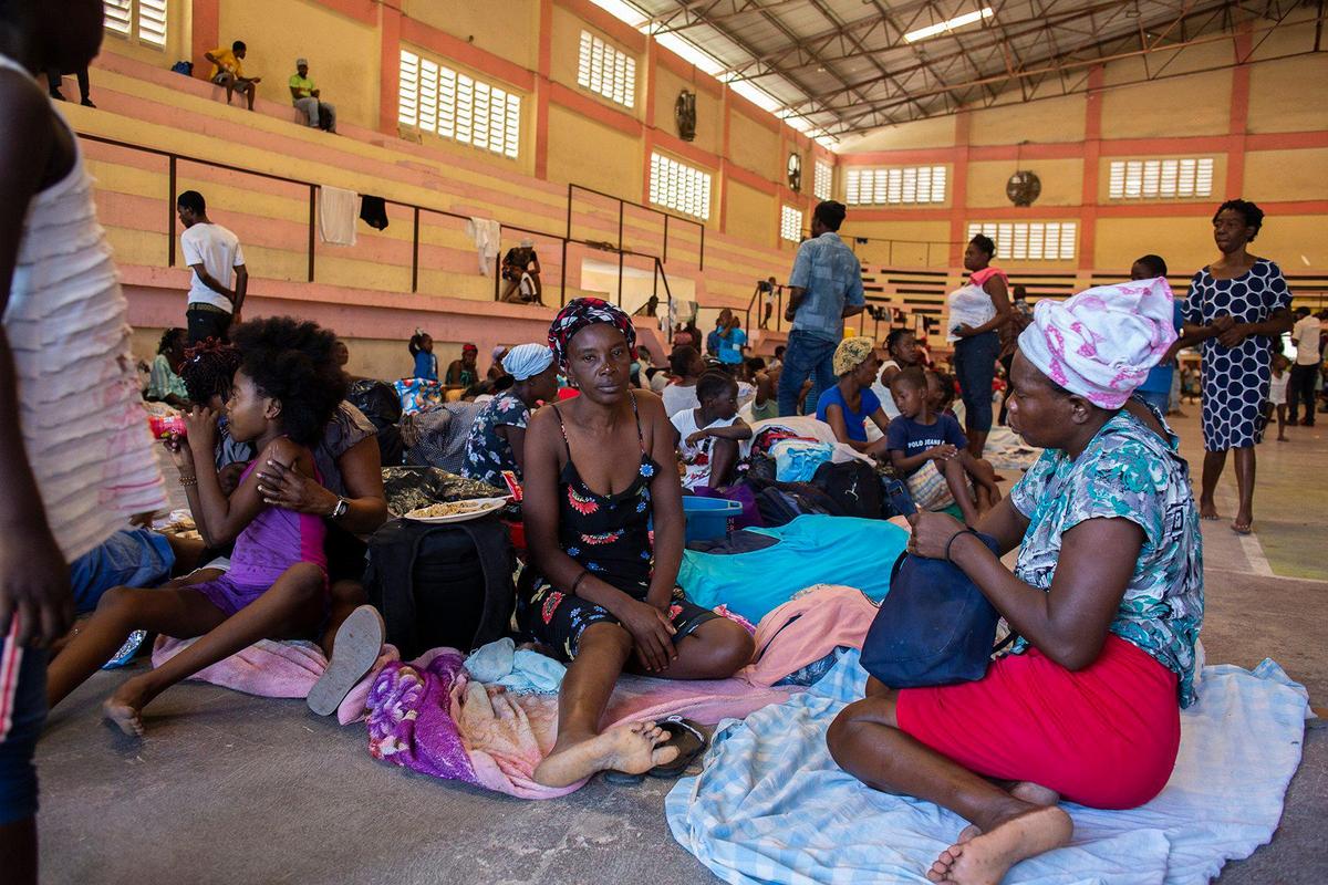 Internally displaced people sit inside a shelter at the Center Sportif of Carrefour in Port-au-Prince, Haiti, Tuesday, June 8, 2021. A UNICEF report says that escalating gang violence has displaced thousands of women and children in the capital in the first two weeks of June.