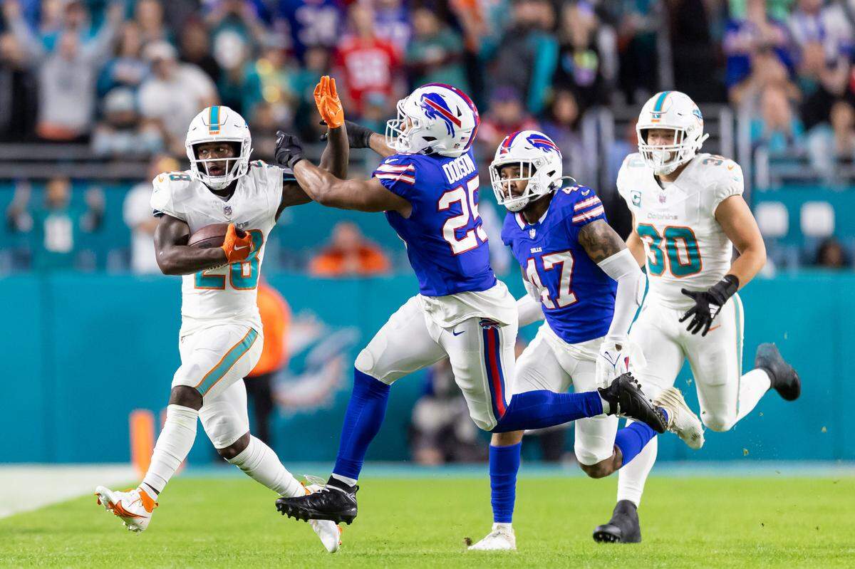 Miami Dolphins running back De’Von Achane (28) runs with the ball as Buffalo Bills linebacker Tyrel Dodson (25) tries to tackle him in the first quarter of an NFL game at Hard Rock Stadium on Sunday, Jan. 7, 2023, in Miami Gardens Fla.