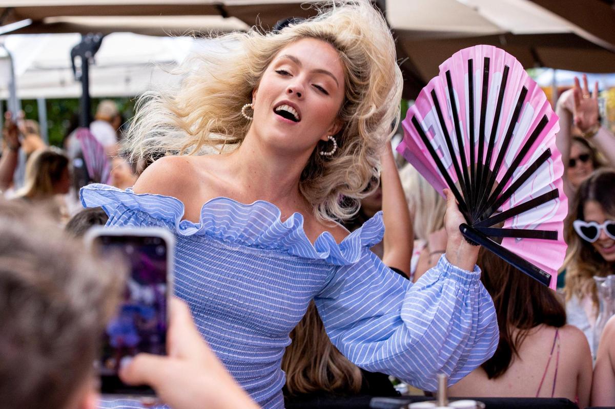 Australian tourist Madison Ivers, 24, dances to the music with a fan in hand during a Drag Brunch at R House Wynwood in Miami, Florida, on Saturday, April 9, 2022.