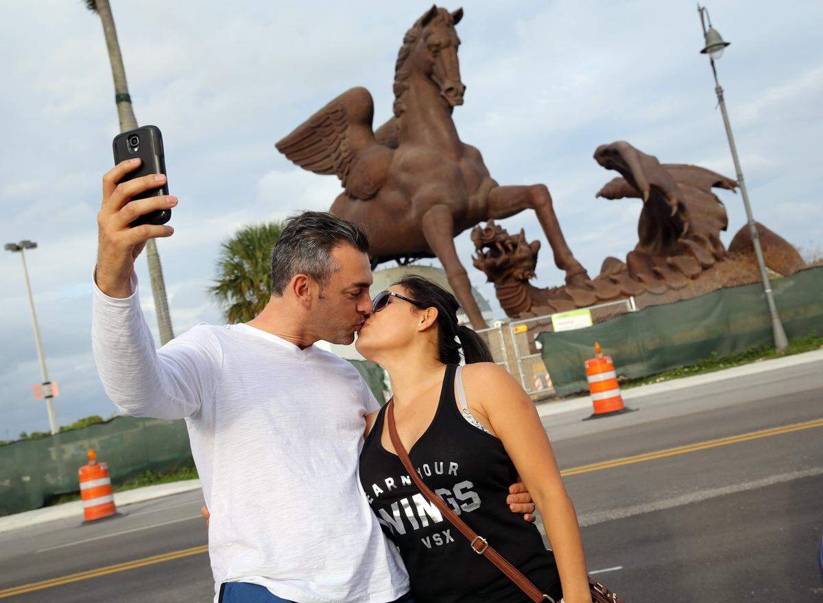 The $30 million bronze Pegasus statue at the Village of Gulfstream Park and a kissing couple taking a selfie.