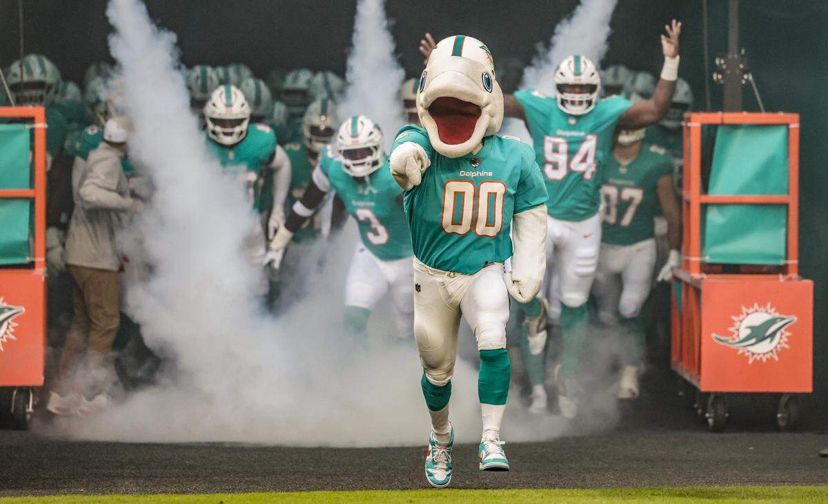 Miami Dolphins mascot T.D. leads the team out of the tunnel before the start of an NFL football game against the Jacksonville Jaguars at Hard Rock Stadium in Miami Gardens, Florida, on Saturday, August 23, 2025.