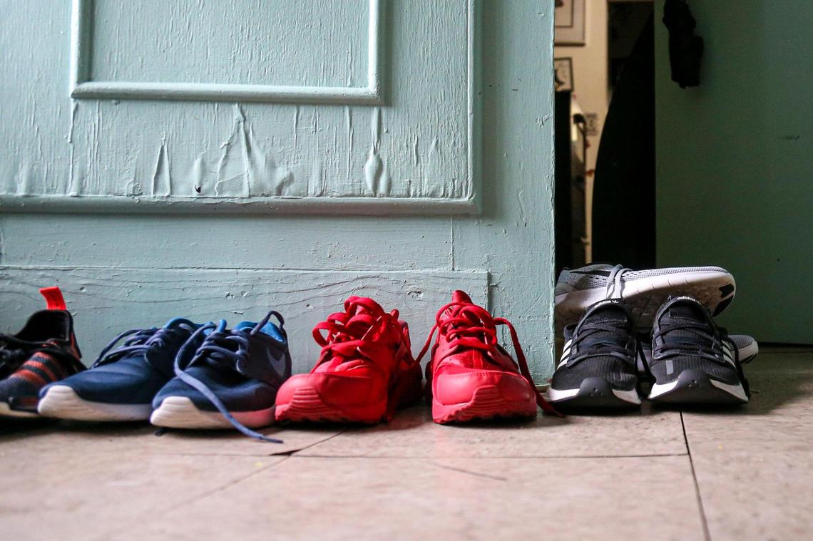 Pairs of shoes from the Murillo family dry off by a door damaged from absorbing water after their rental home flooded due to a weekend of heavy rainfall in the neighborhood of Little Havana in Miami, Florida, on Friday, June 10, 2022.