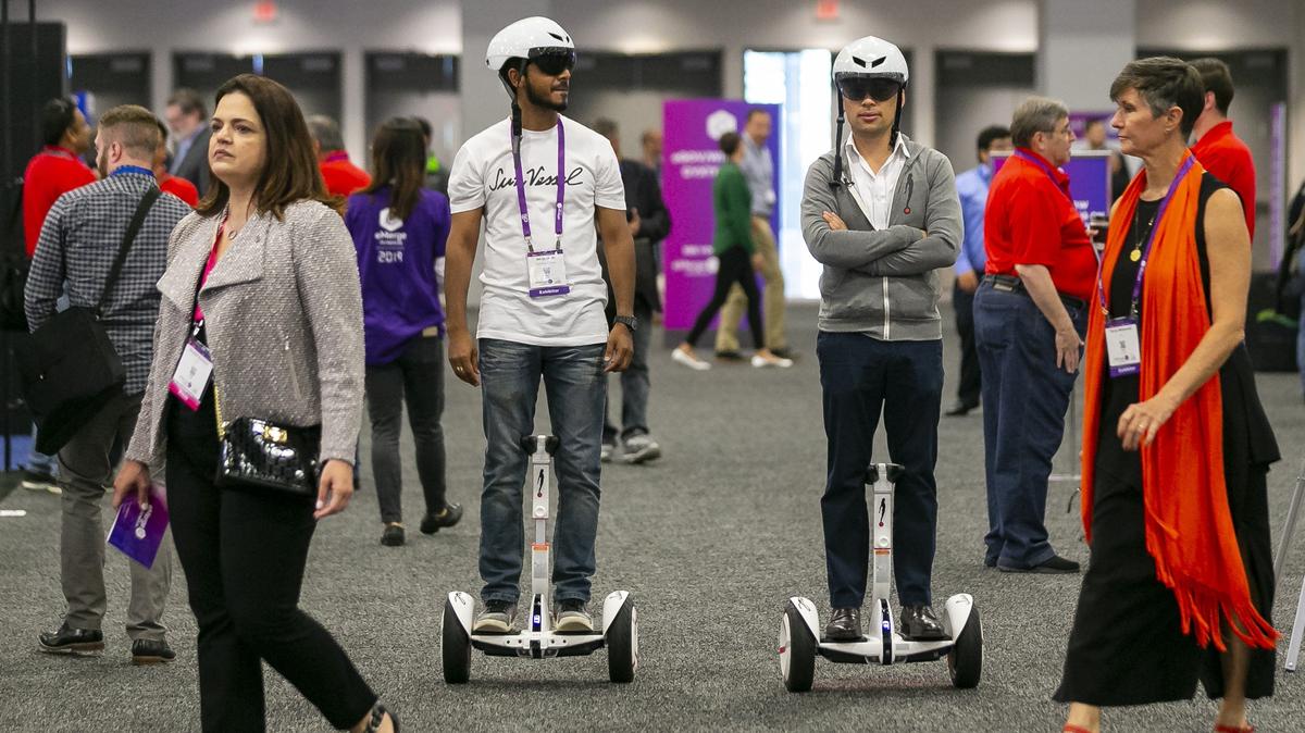 Ali Qureshi, 32, left, a lead designer, and Sebastian Gomez Puerto, 33, CEO and founder, demonstrate how the SunVessel operates during the technology conference, eMerge Americas, inside the Miami Beach Convention Center in Miami Beach on April 29, 2019. SunVessel is an electric and robotic personal mobility device installed inside hotels, offices, and apartment buildings, which aims to offer a different mode of transportation in cities like Miami.