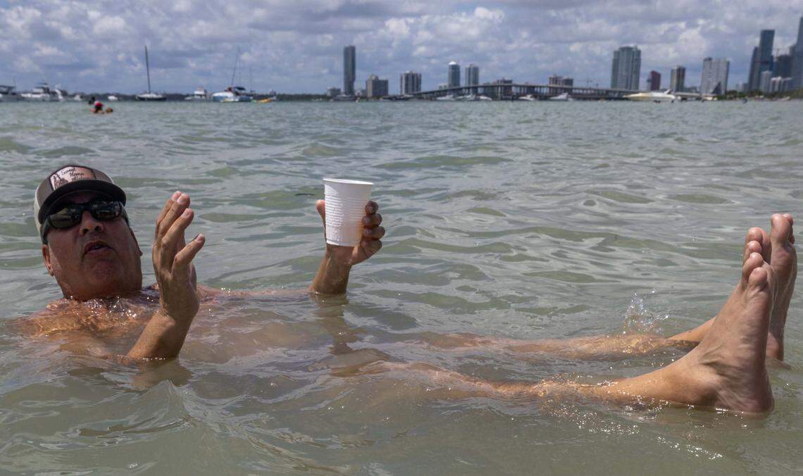 A Miami native hangs in the shallow water at Hobie Island Beach on Monday, September 1, 2025, in Key Biscayne, Fla.