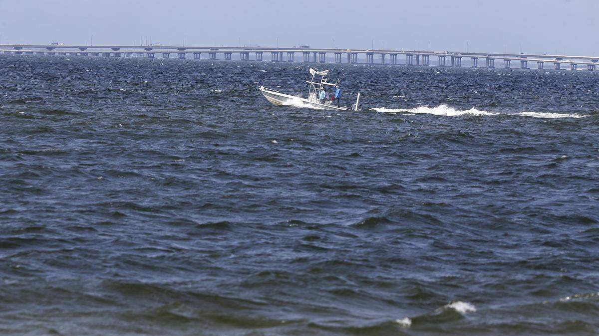 A boat passes along the waters of Old Tampa Bay with the Howard Frankland Bridge in the distance on Oct. 25, 2021, in Tampa, Florida.