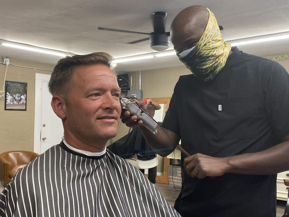 Scottie Etheridge, of Key West, gets a trim from barber Vontay Gardner on May 11, 2020, as barber shops reopened in most of Florida.