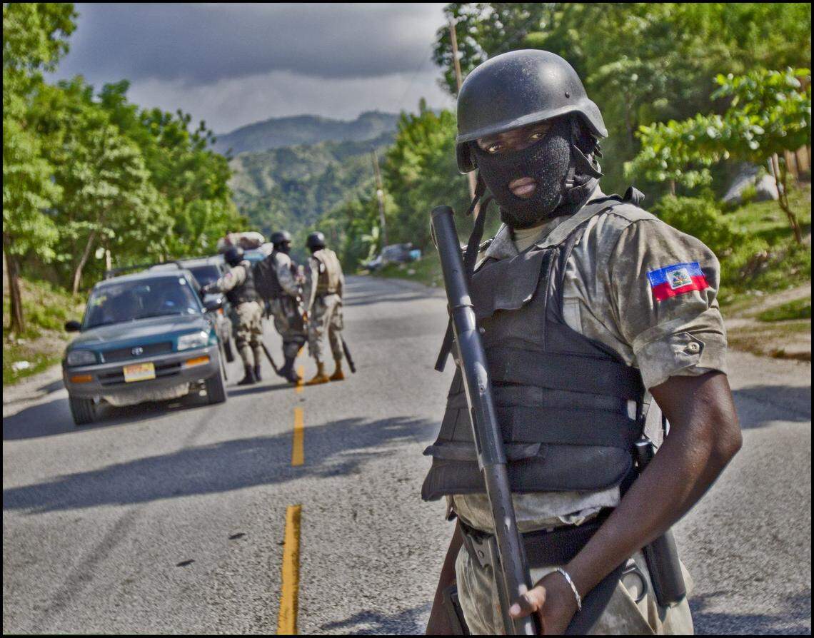 A tactical Haitian National Police officer participates in a security checkpoint in 2013 along National Highway 2 in Petit-Goave, Haiti, where armed gangs of masked gunmen had set up roadblocks to ambush unsuspecting motorists.