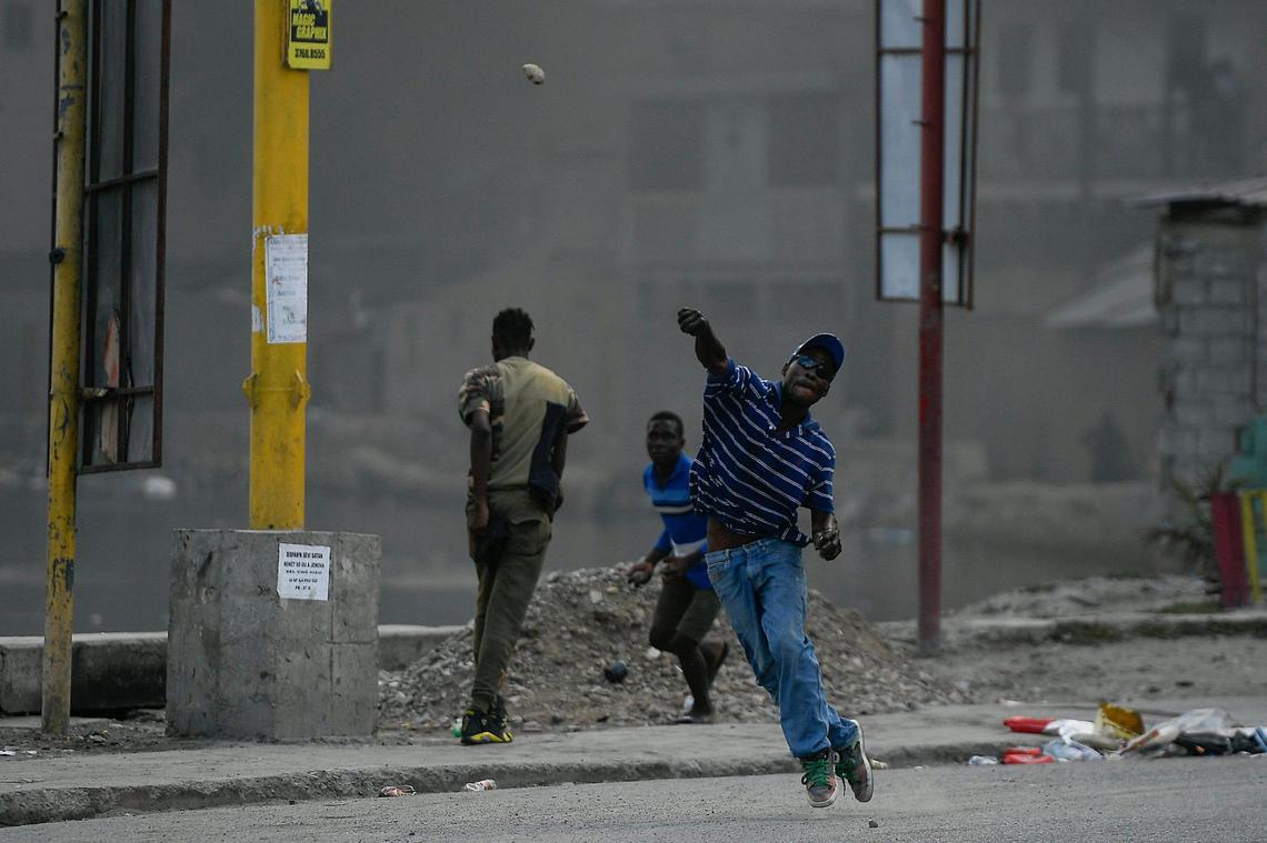 A protester demanding justice for the assassinated President Jovenel Moïse hurls a stone in Cap-Haitien, Haiti, Thursday, July 22, 2021. Demonstrations after a memorial service for Moïse turned violent with protesters shooting into the air, throwing rocks and overturning heavy concrete barricades next to the seashore as businesses closed and people took cover.