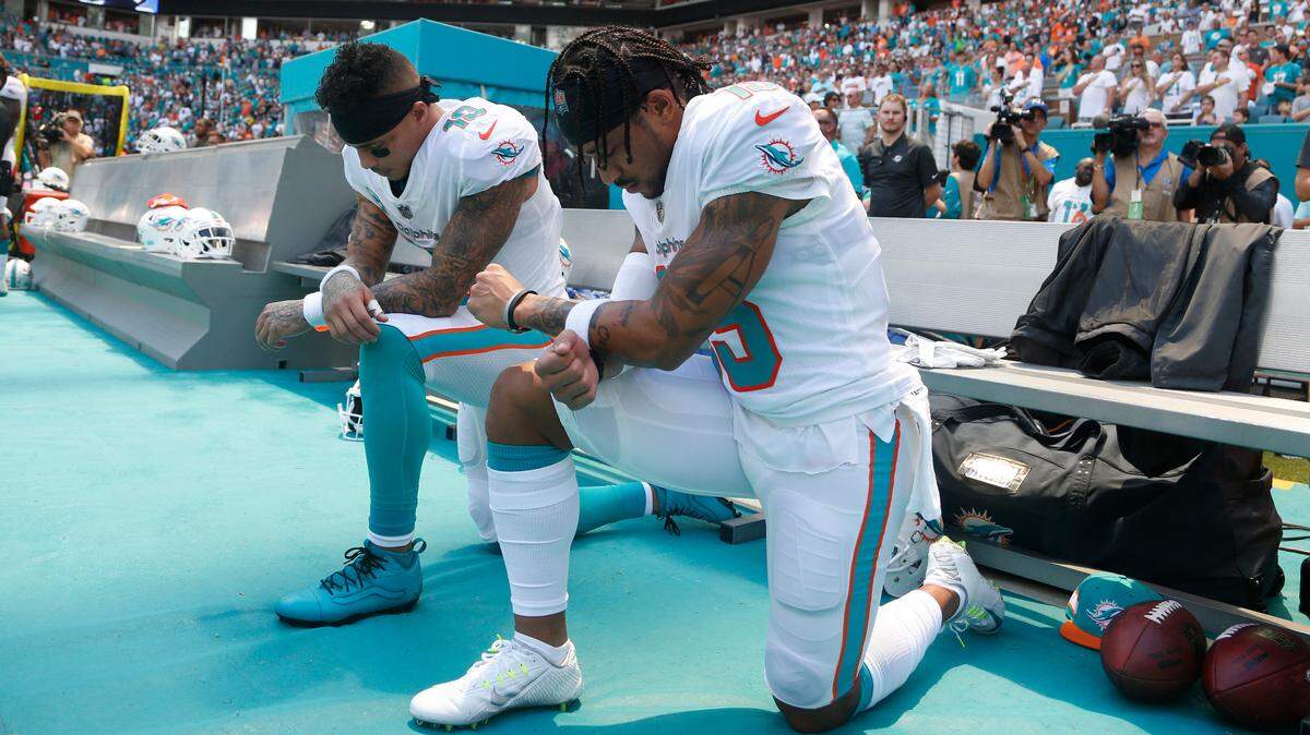 Miami Dolphins wide receiver Kenny Stills, left, and Miami Dolphins wide receiver Albert Wilson kneel during the national anthem before Sunday’s game against the Tennessee Titans.