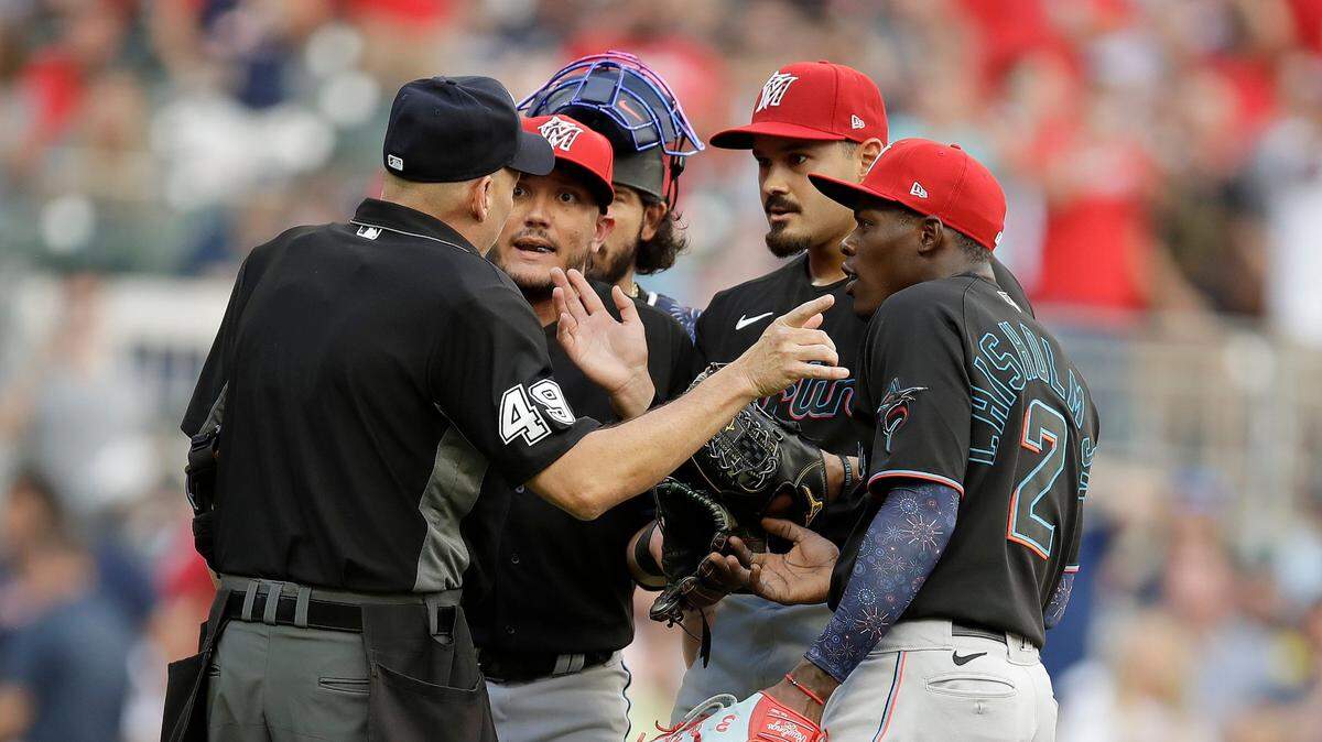 Home plate umpire Andy Fletcher, left, speaks with Miami Marlins pitcher Pablo Lopez, second from right, shortstop Miguel Rojas, second from left, and second baseman Jazz Chisholm Jr. (2) during the first inning of a baseball game against the against the Atlanta Braves on Friday, July 2, 2021, in Atlanta. Lopez and manager Don Mattingly were both ejected. (AP Photo/Ben Margot)