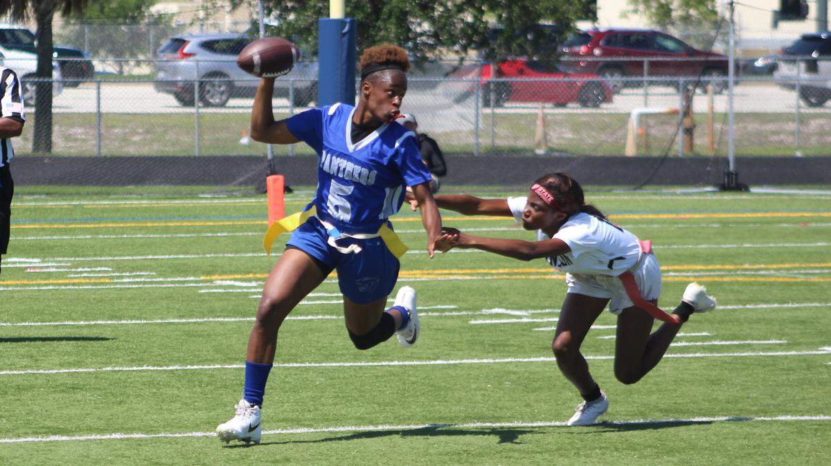 Dillard quarterback Genovea Johnson turns the corner past diving Tampa Robinson defender Chelsey Campbell during Saturday afternoon’s flag football 1A state championship game at Boca Raton High School.