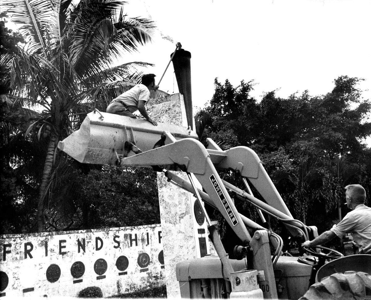 A worker relights Torch of Friendship after it had been turned off for the connection of a new gas line at the nearby Bayfront Park marina.