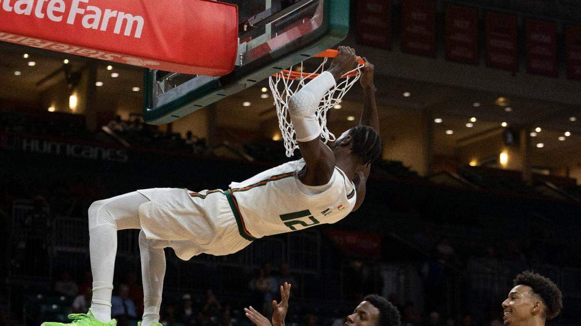 Miami center Favour Aire (12) hangs on the basket after dunking the ball during the second half of a NCAA men’s basketball game between the University of Miami Hurricanes and the St. Francis Brooklyn Terriers on Wednesday, Nov. 23, 2022, at the Watsco Center in Coral Gables. Miami won 79-56.