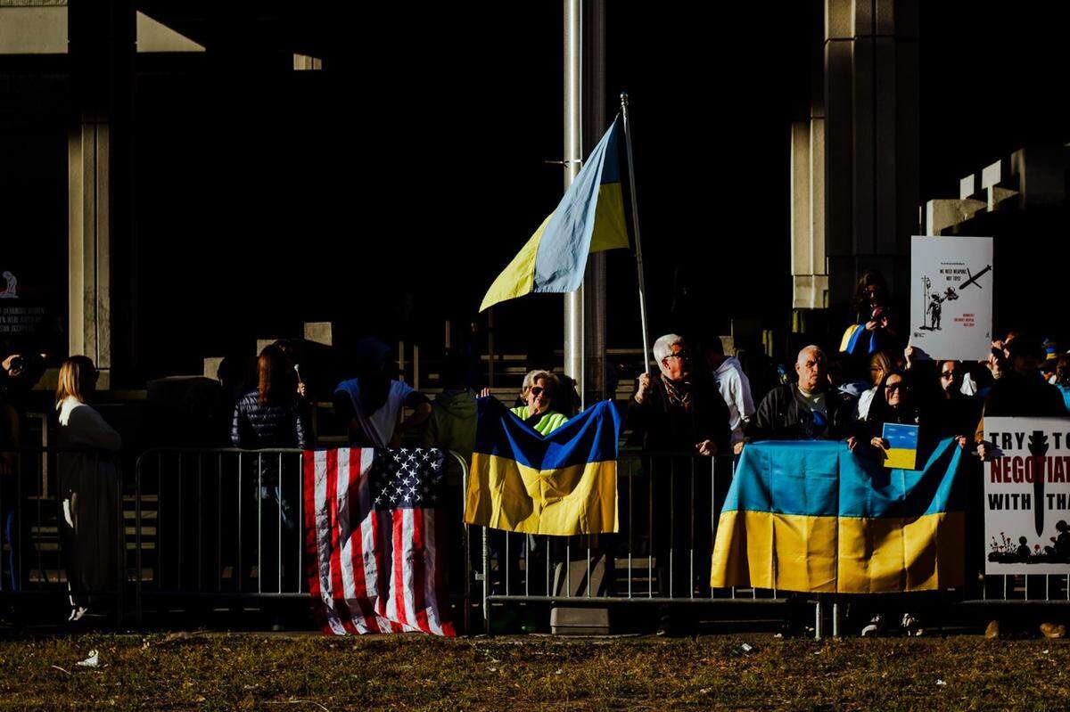 People holding up posters and flags in support of Ukraine.