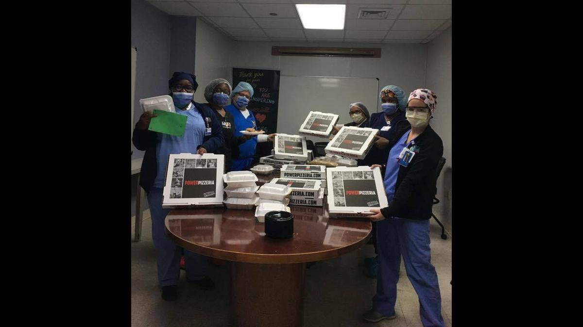 Healthcare workers at Jackson Memorial Hospital enjoy pizzas donated by Gulliver alum E.J. Martinez, owner and founder of Power Pizzeria. More than 3,000 pizzas have been donated to hospital workers and children’s groups.