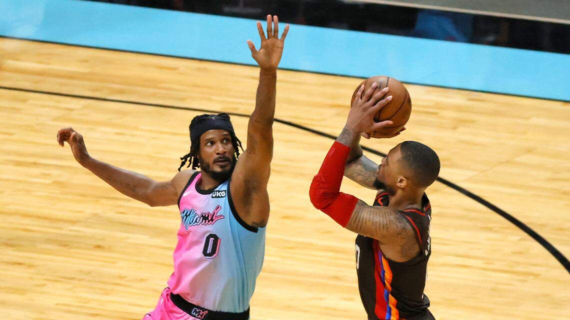 Portland Trail Blazers guard Damian Lillard (0) attempts a triple while Miami Heat forward Trevor Ariza (0) fouls in the fourth quarter of his NBA basketball game at AmericanAirlines Arena on Thursday, March 25, 2021.