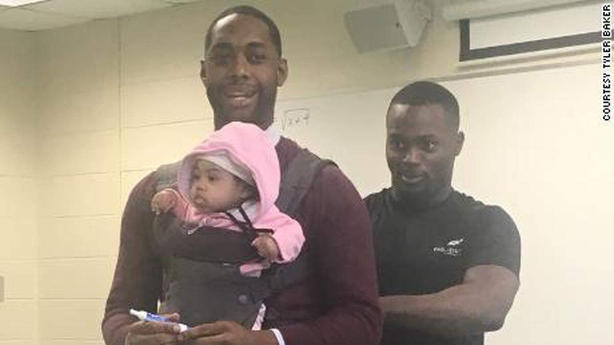 Student Wayne Hayer fastens his daughter’s carrier around math professor Nathan Alexander at Morehouse College.