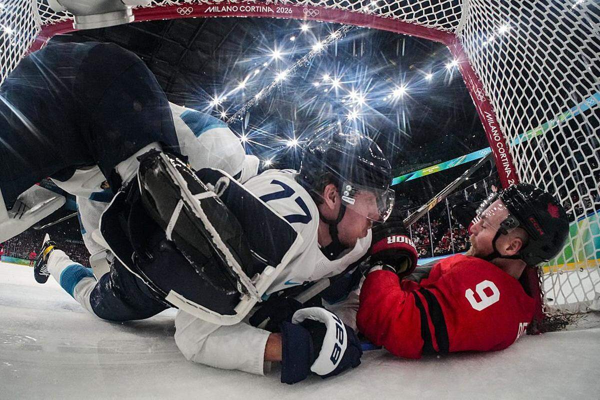 Canada's #09 Sam Bennett (R) and Finland's #77 Niko Mikkola (C) fall into the goal during the men's play-off semi-final ice hockey match between Canada and Finland at the Milano Santagiulia Ice Hockey Arena during the Milano Cortina 2026 Winter Olympic Games in Milan, on February 20, 2026. (Photo by POOL / AFP via Getty Images)