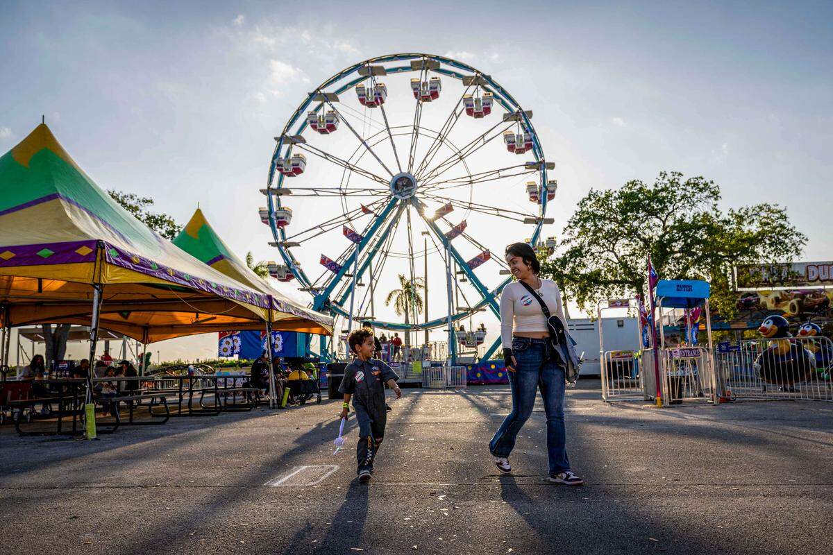 Elijah Iacono, 5, walks with his mother at the Miami-Dade County Fair & Exposition