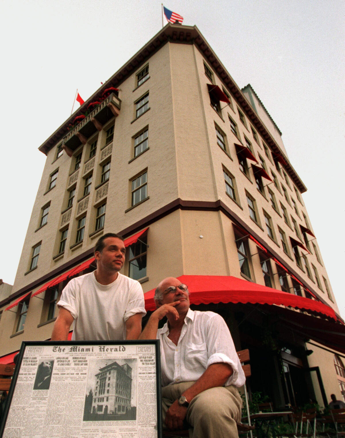 In this file photo from Sept. 21, 1994, Van Dyke Cafe owners Jeffrey Davis and Mark Soyka pose near the restaurant and jazz music venue they opened on Lincoln Road. The Van Dyke building was originally a Carl Fisher building built by Miami Beach founder’s in 1924 as seen in the old Miami Herald page Davis and Soyka are holding.