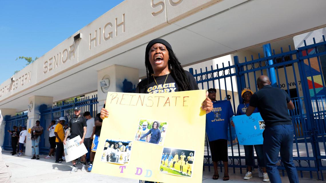 Nay Akins holds a sign while shouting during a rally to show support for the reinstatement of suspended Miami Northwestern football coach and former Miami Dolphins quarterback Teddy Bridgewater outside of Miami Northwestern Senior High School in Miami, Florida, Thursday, July 24, 2025.