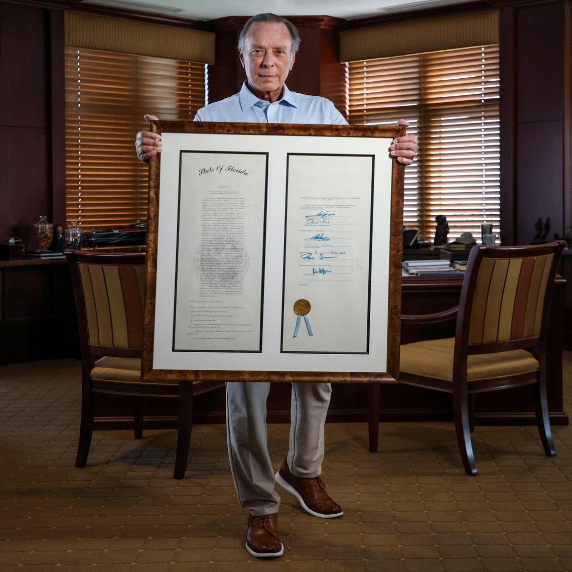 Philanthropist Miguel “Mike” B. Fernandez holds the bill he supported for in-state tuition for undocumented students that became law and vows to yank his $1 million pledge to FIU until the state reinstates in-state tuition waivers for undocumented students on Tuesday, June 24, 2025, in Coral Gables, Florida.