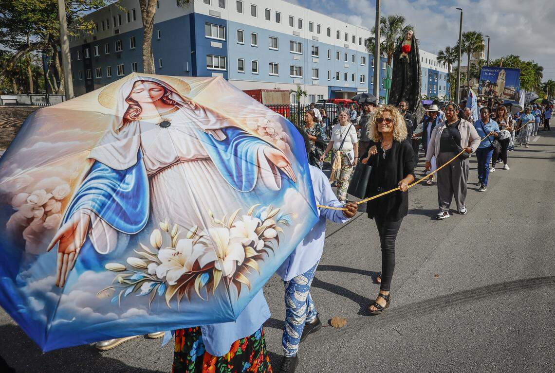 An image of the Virgin Mary is displayed on an umbrella during the Stations of the Cross procession along Northwest Second Avenue near St. Mary Cathedral on Friday, April 3, 2026, in Miami.