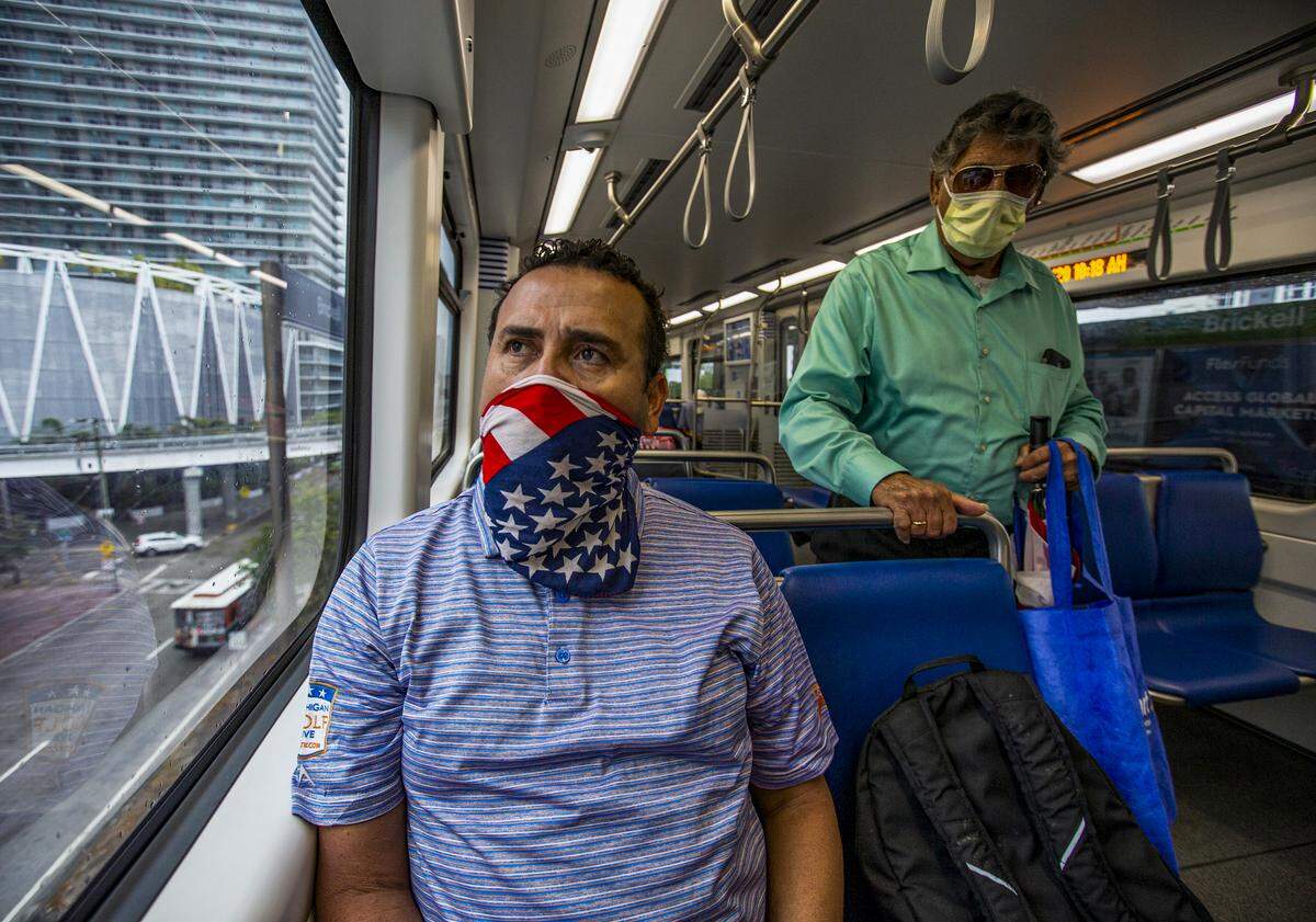 Metrorail passenger Gregorio Moya, 51, wears a scarf bearing the American flag to help protect himself from the coronavirus in Miami-Dade on Wednesday, April 1, 2020.