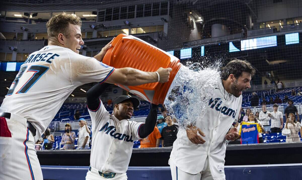 Miami Marlins center fielder Jakob Marsee (87) and second baseman Xavier Edwards (9) pour cold water on catcher Joe Mack (80) after he scored a walk-off run against the Baltimore Orioles to win their MLB game at loanDepot park on Thursday, May 7, 2026, in Miami, Fla.